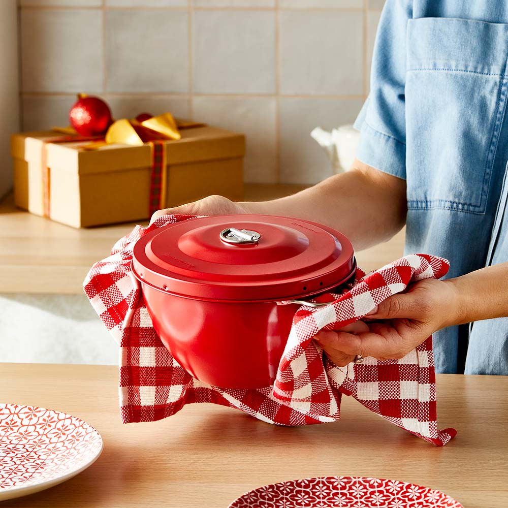 woman holding red pudding steamer