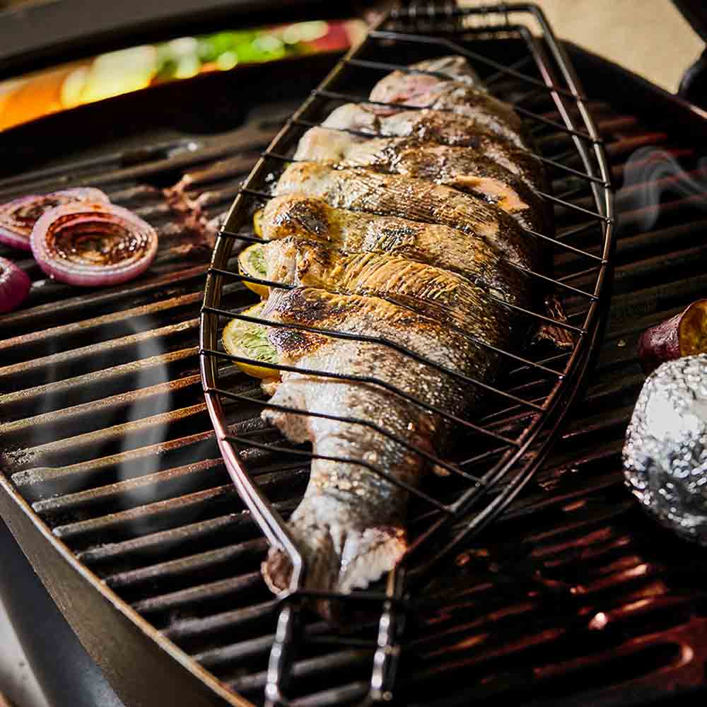 Full fish grilling in a steel fish basket on the BBQ - Robins Kitchen