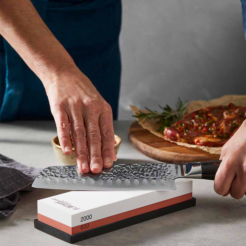 woman sharpening knife using a whetstone - Robins Kitchen