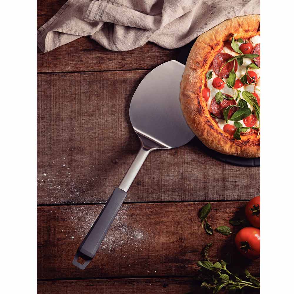 Tramontina Pizza Spatula - Paddle scooped under pizza - Robins Kitchen