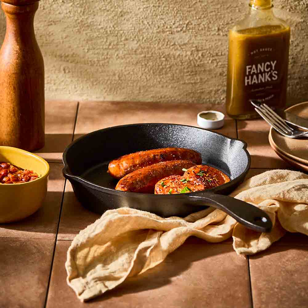cooked sausages and onions in a cast iron frypan - Robins Kitchen