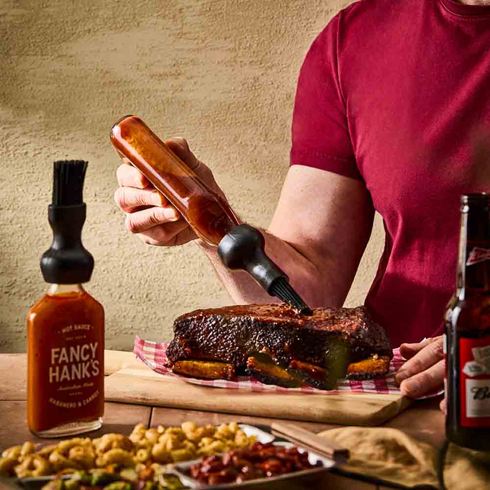 man basting steak with basting bottle cap brush - Robins Kitchen
