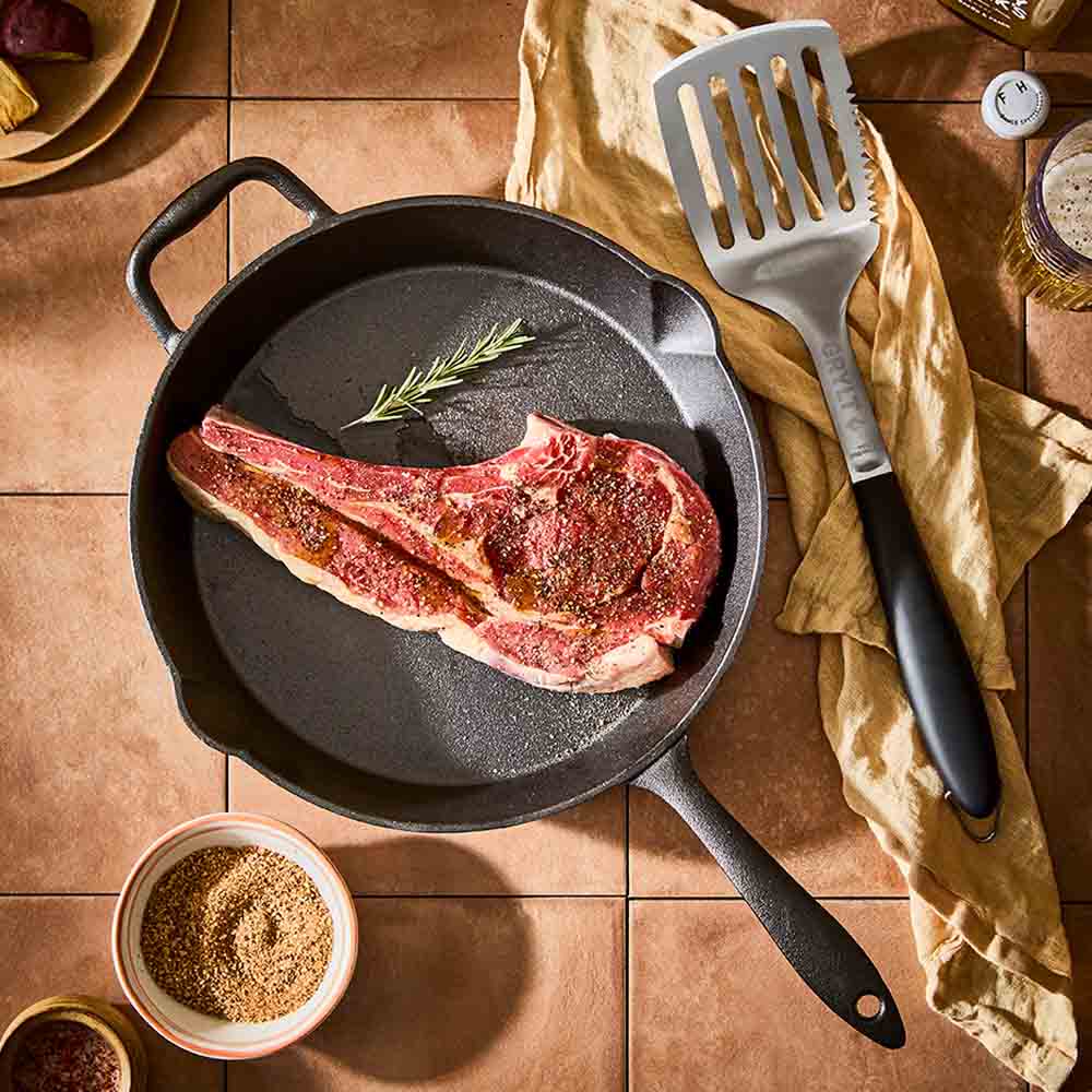 BBQ slotted turner next to cast iron pan with steak - Robins Kitchen