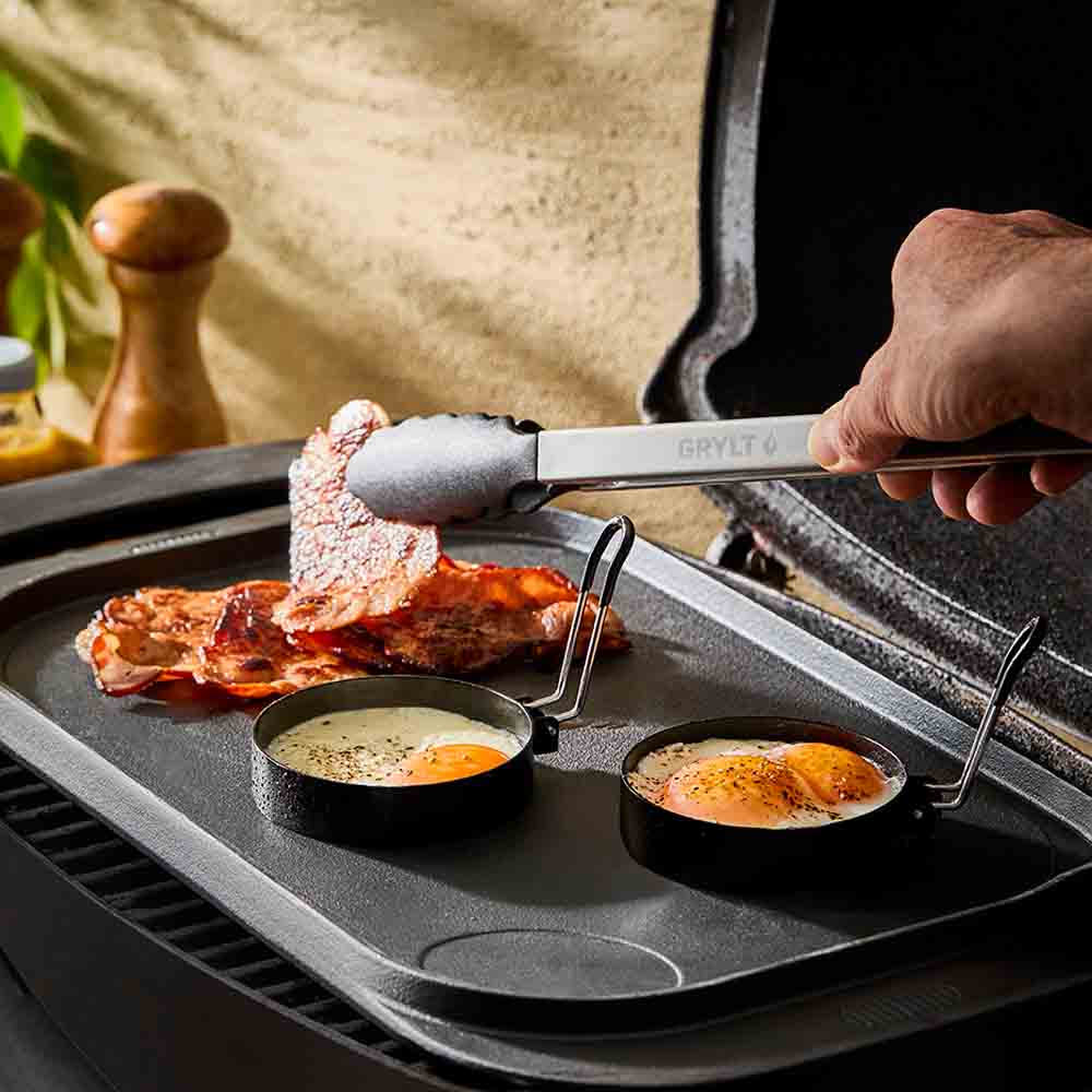 man cooking on the BBQ with steel egg rings with lever - Robins Kitchen