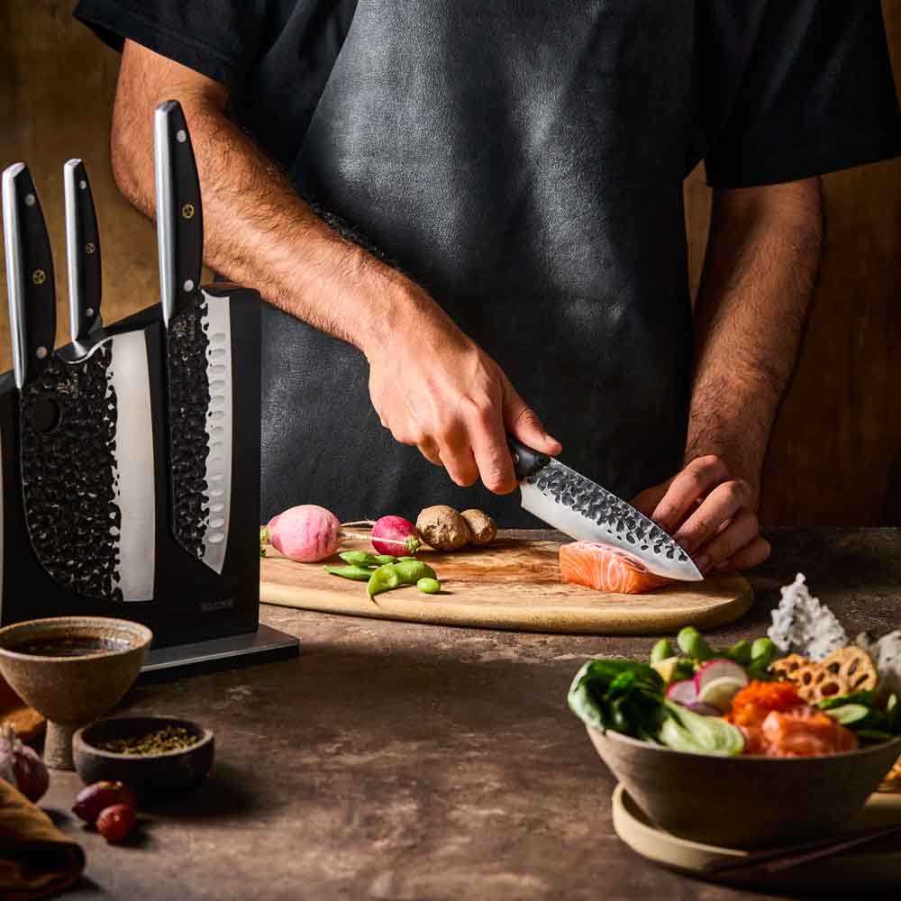 Man slicing salmon with Baccarat KUROI KIBA 7 Piece Knife Block at Robins Kitchen