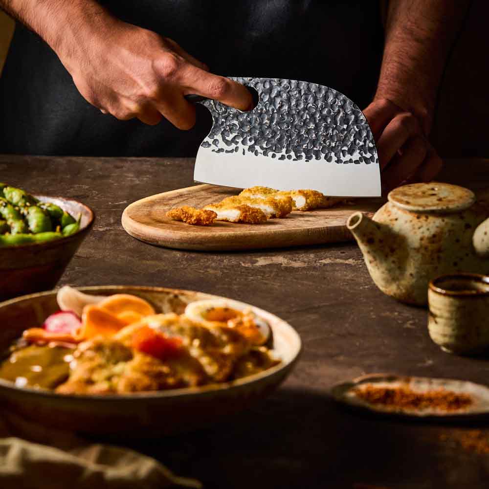 Man slicing katsu chicken with Baccarat KUROI KIBA Moon Knife 17.5cm at Robins Kitchen