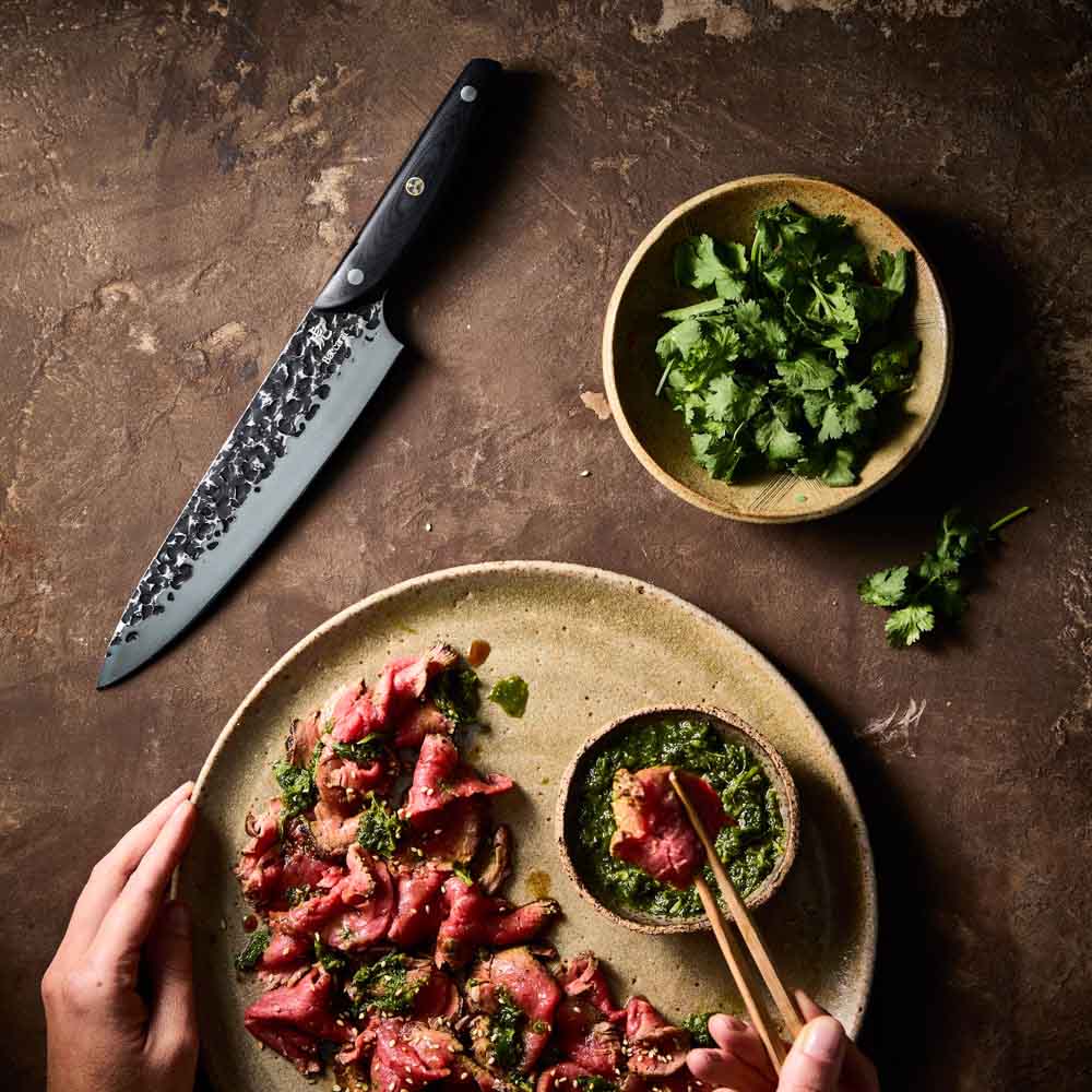 Man dipping sliced wagyu beef - Baccarat KUROI KIBA Chefs Knife 20cm at Robins Kitchen