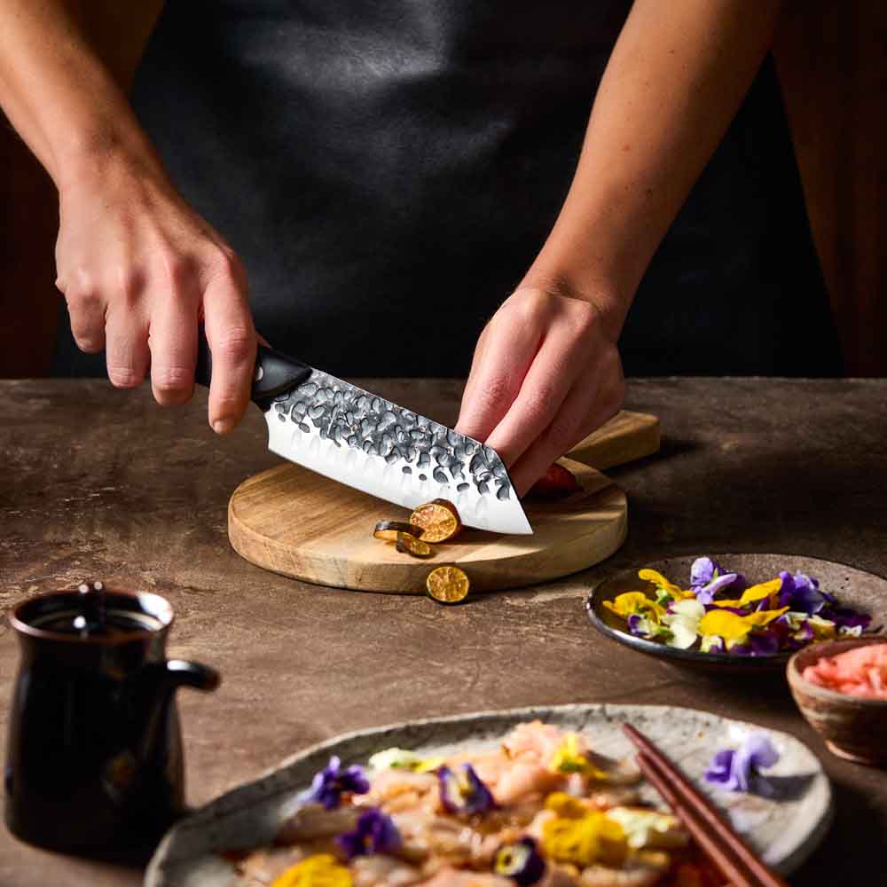 Woman slicing eggplant with Baccarat KUROI KIBA Santoku Knife 14cm at Robins Kitchen