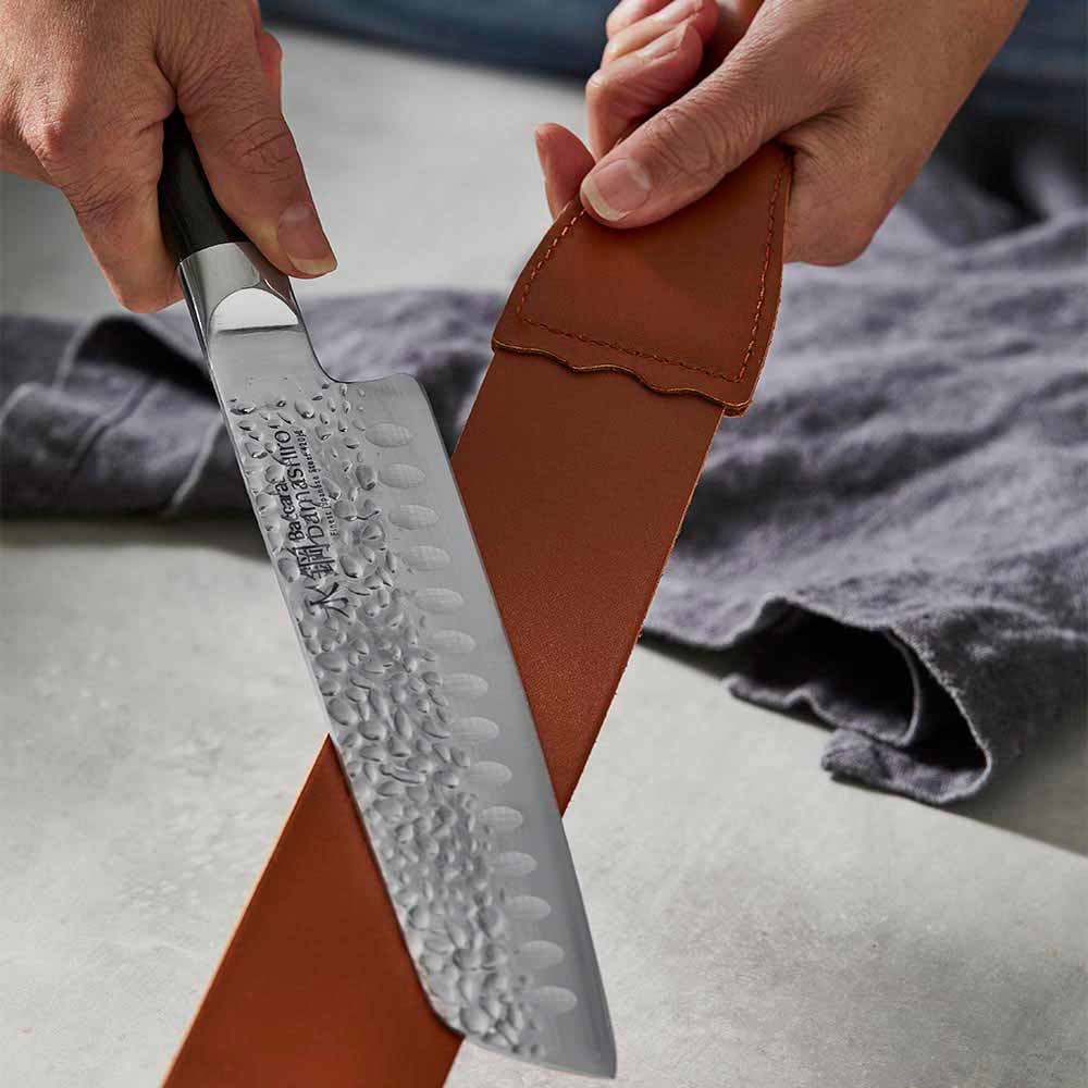 woman polishing knife with leather strop - Robins Kitchen