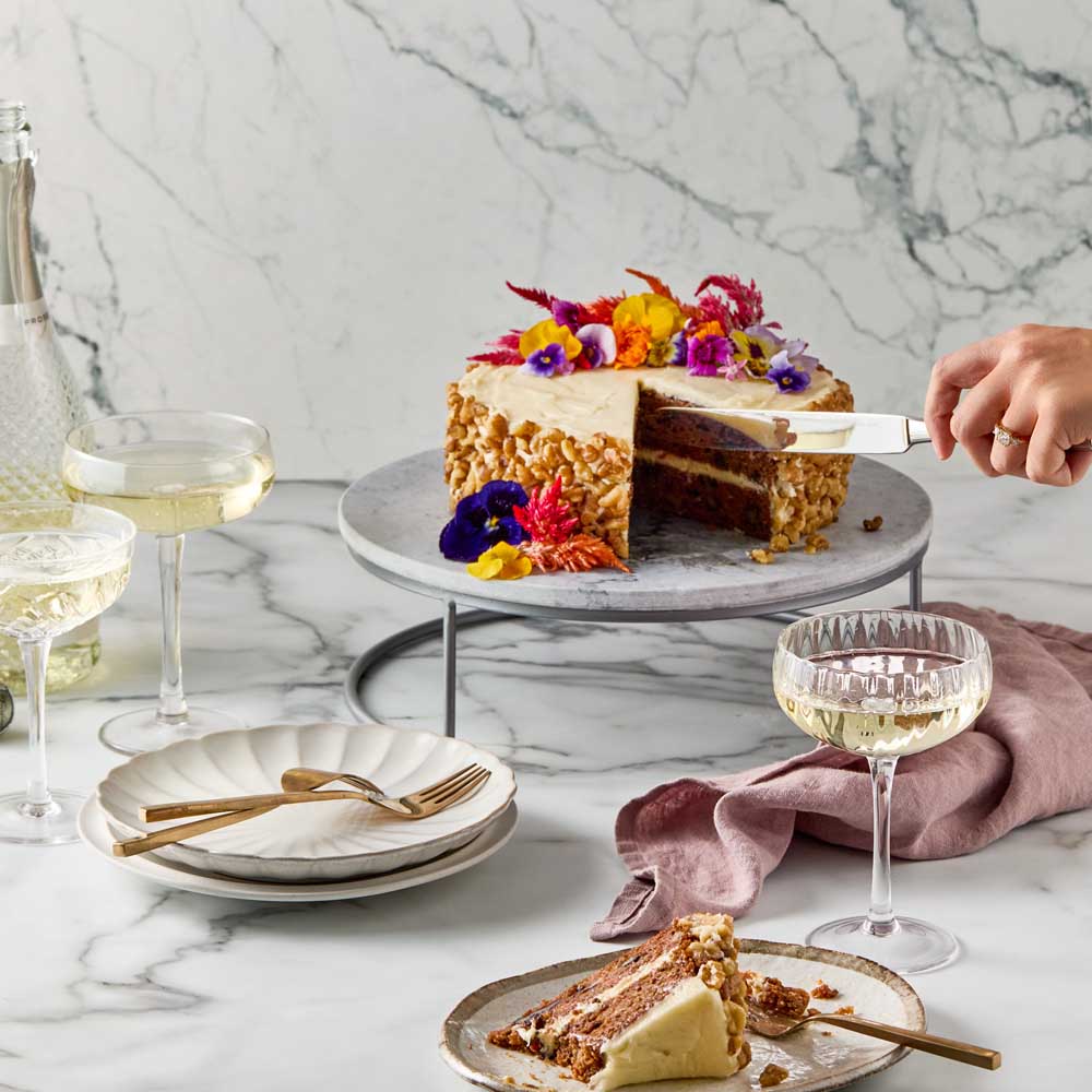 woman cutting slice of cake from marble serving board - Robins Kitchen