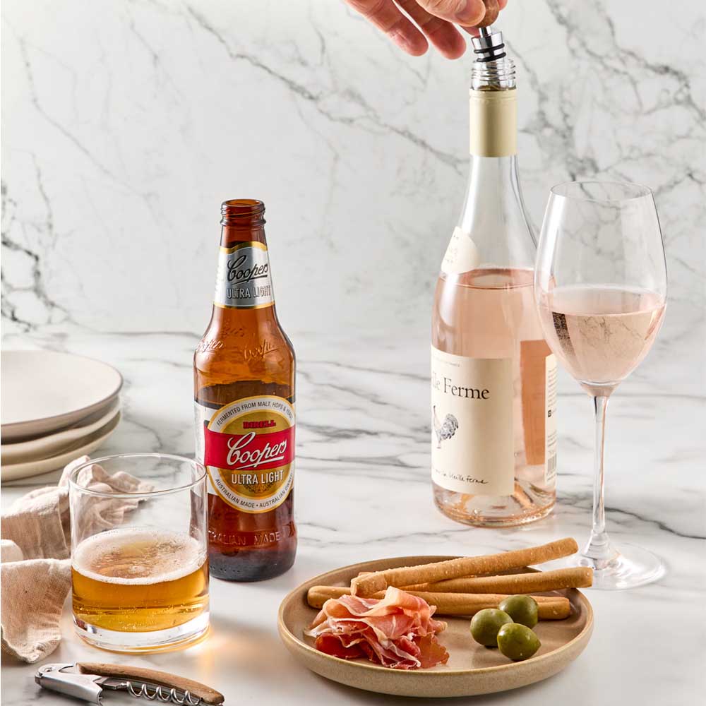 Wood Bottle Opener next to beer and Bottle Stopper  into wine bottle - Robins Kitchen