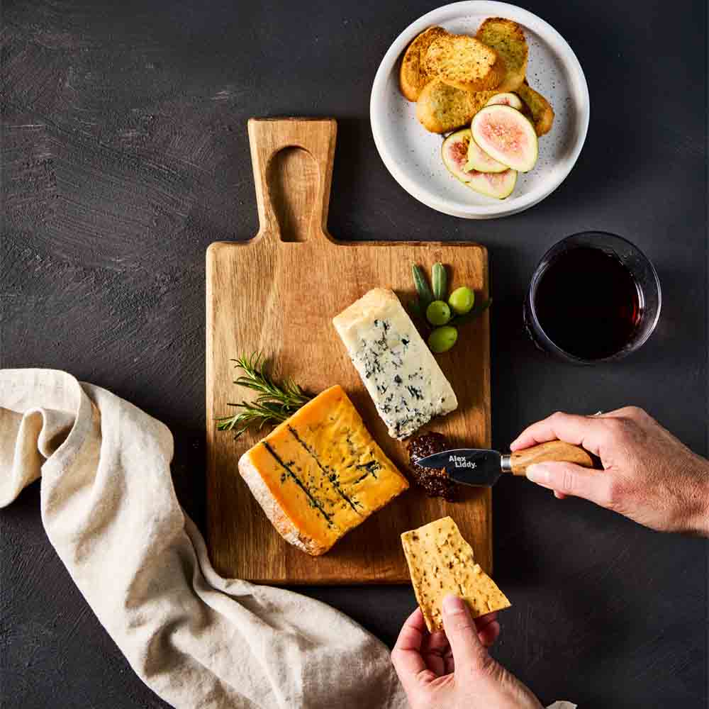 person cutting into quince paste on cheese board with knife - Robins Kitchen