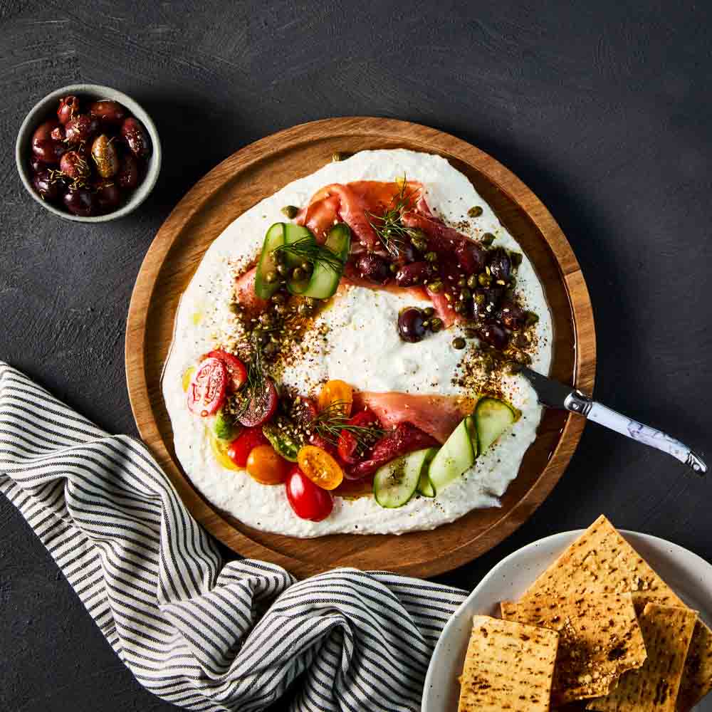 dip with corn chips on a round wooden platter - Robins Kitchen